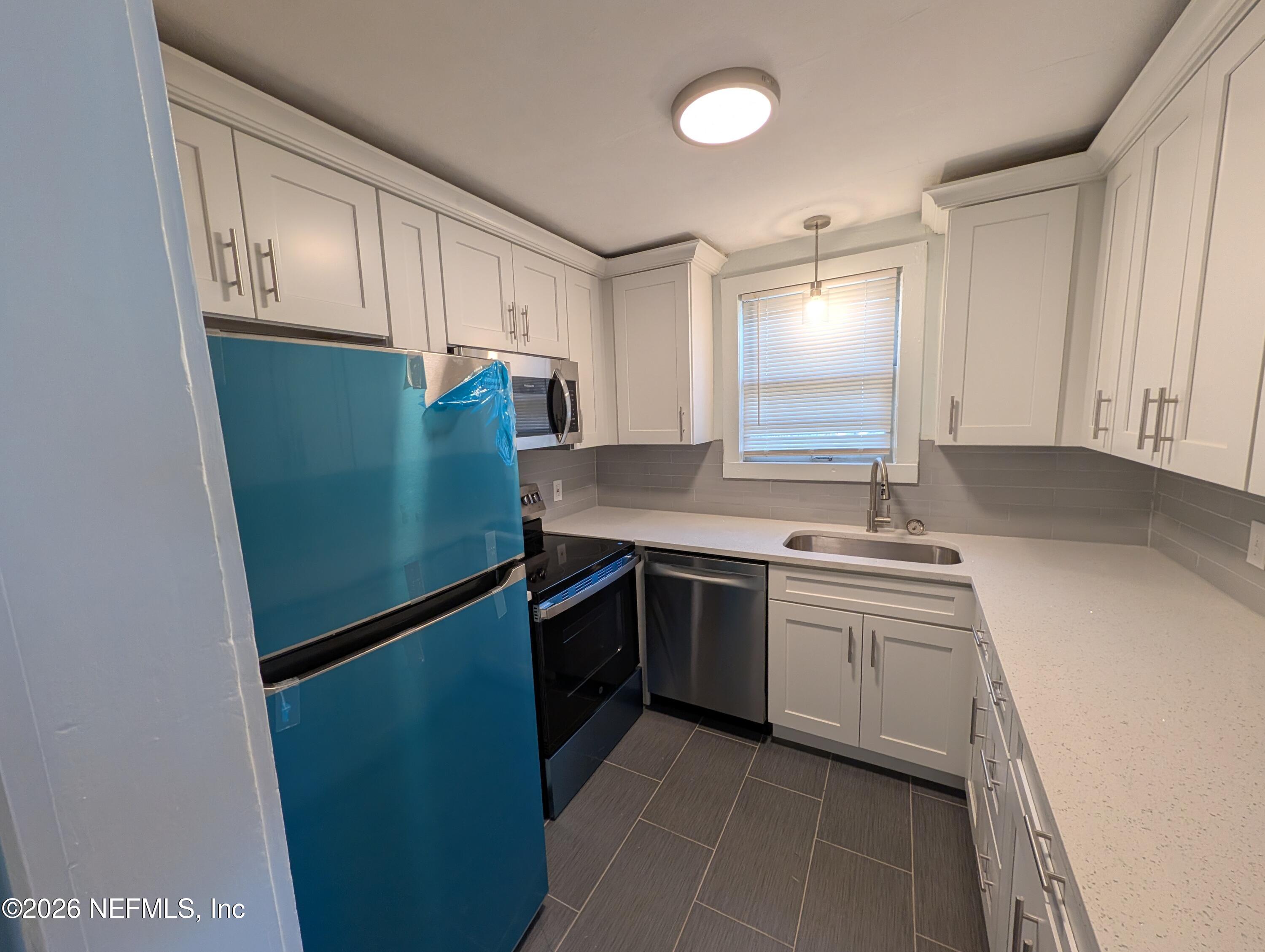 1438 Dancy Street Jacksonville, FL 32205 - Photo 46 of 49 a kitchen with stainless steel appliances granite countertop a refrigerator and a sink