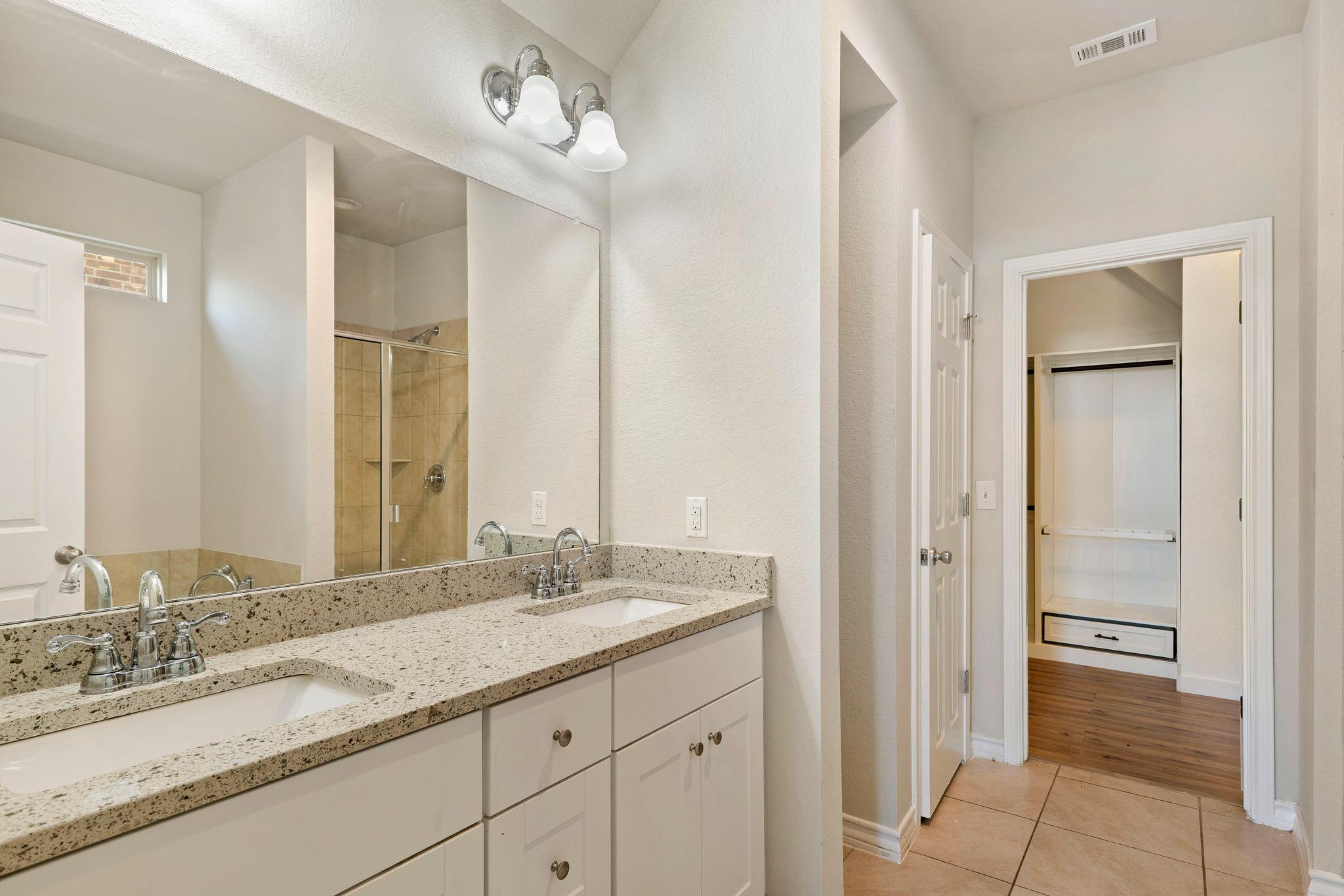 1341 Eagle Ray Street Leander, TX 78641 - Photo 17 of 37 Double vanities with sleek granite countertops and modern fixtures create a refreshing bath retreat.
