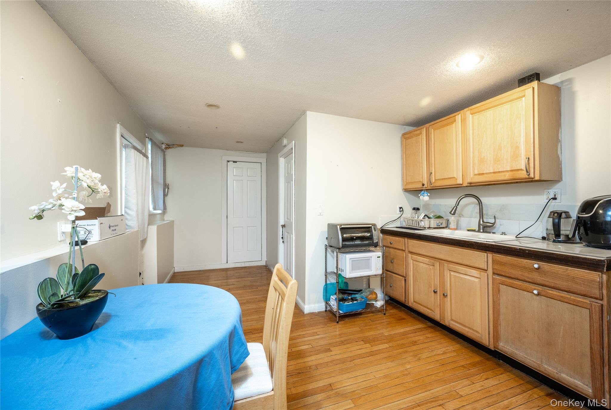929 Fox Meadow Road Yorktown Heights, NY 10598 - Photo 20 of 32 a kitchen with stainless steel appliances granite countertop a sink dishwasher with a dining table chairs with wooden floor