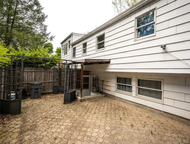 a view of a house with a small yard and wooden fence