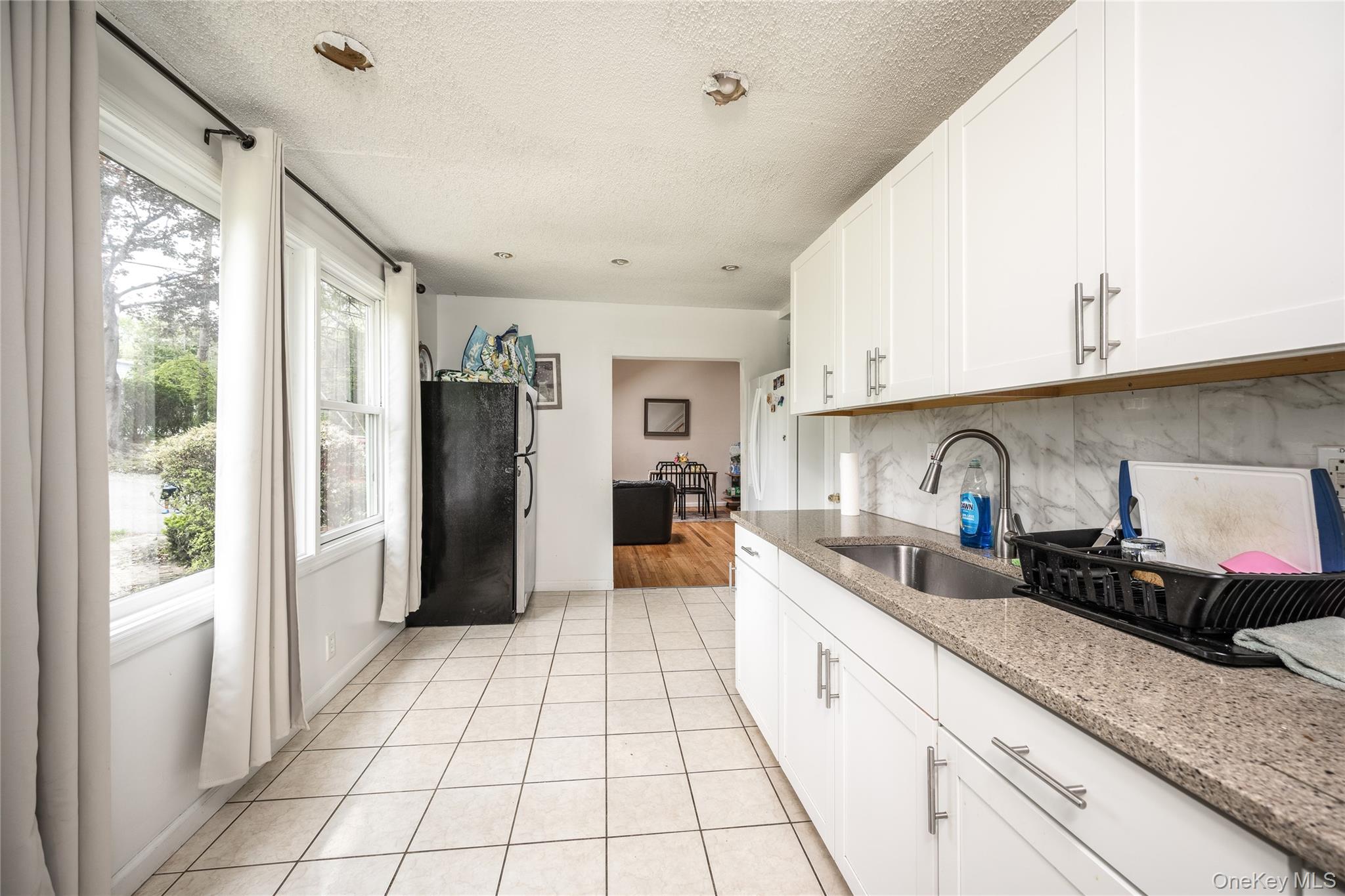 929 Fox Meadow Road Yorktown Heights, NY 10598 - Photo 9 of 32 a large white kitchen with a refrigerator a sink dishwasher a stove and white cabinets with wooden floor