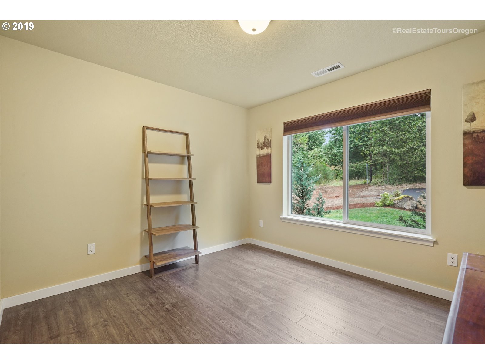 11909 Southeast Laughing Water Road Sandy, OR 97055 - Photo 12 of 22 an empty room with wooden floor and windows