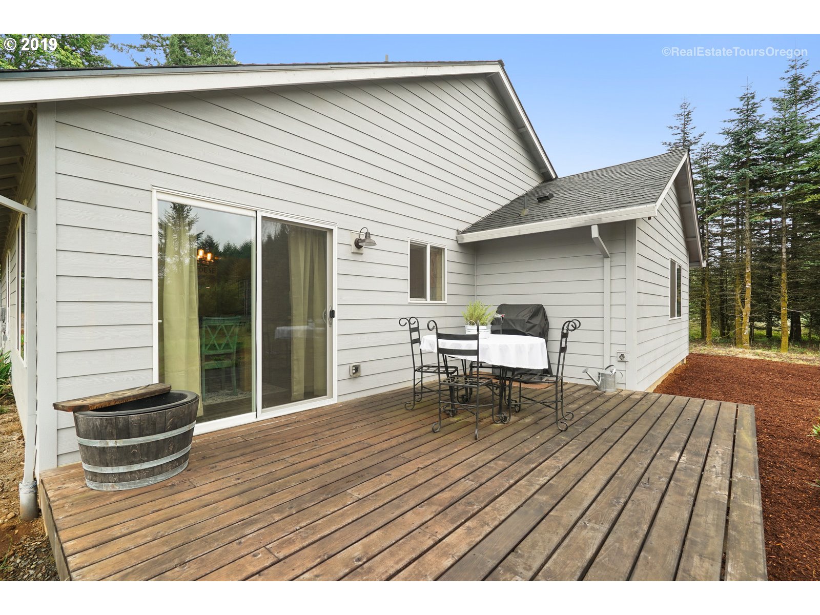 11909 Southeast Laughing Water Road Sandy, OR 97055 - Photo 15 of 22 a backyard of a house with wooden floor outdoor seating and yard in the back