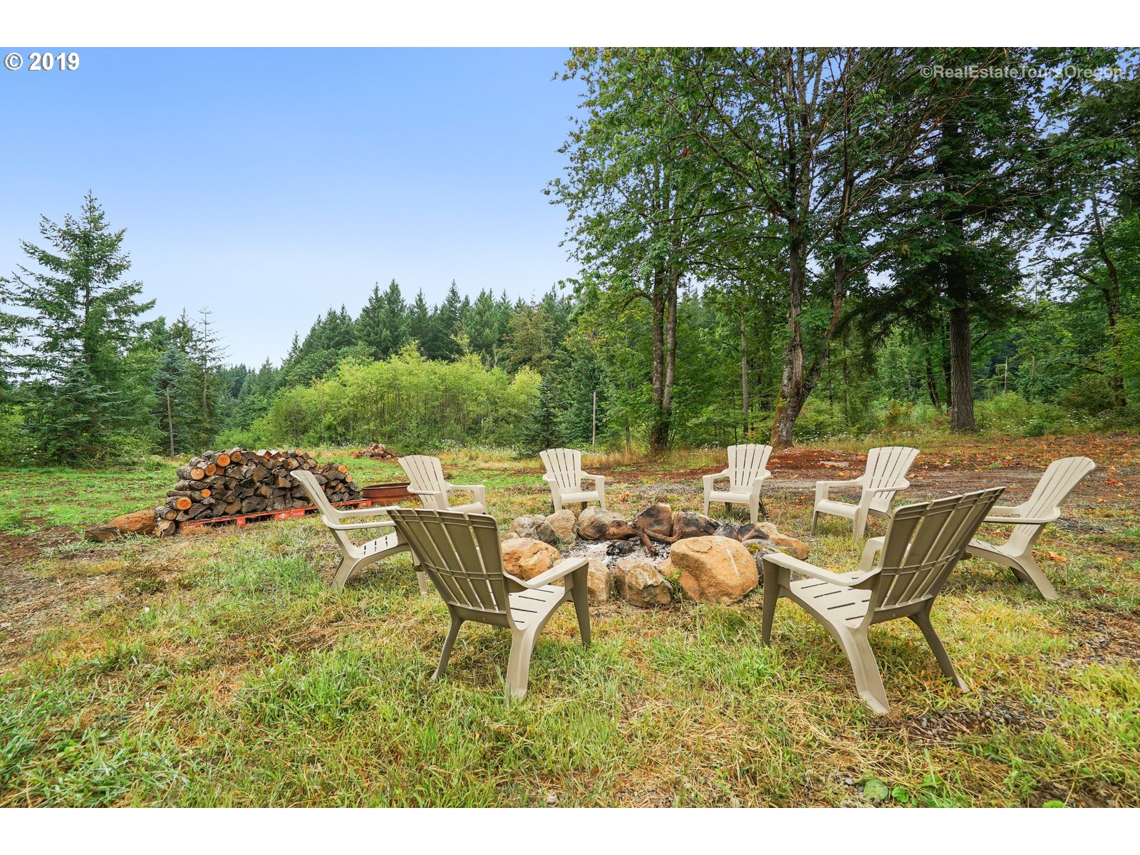 11909 Southeast Laughing Water Road Sandy, OR 97055 - Photo 16 of 22 a view of a patio with table and chairs and potted plants with large tree