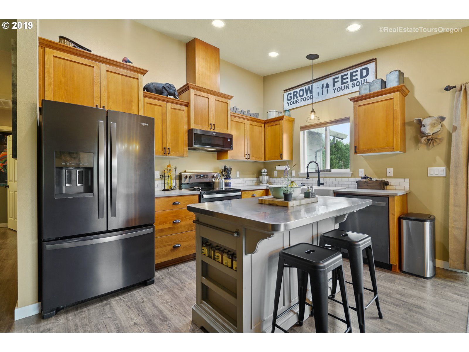11909 Southeast Laughing Water Road Sandy, OR 97055 - Photo 3 of 22 a kitchen with stainless steel appliances a refrigerator a sink a stove a kitchen island and chairs