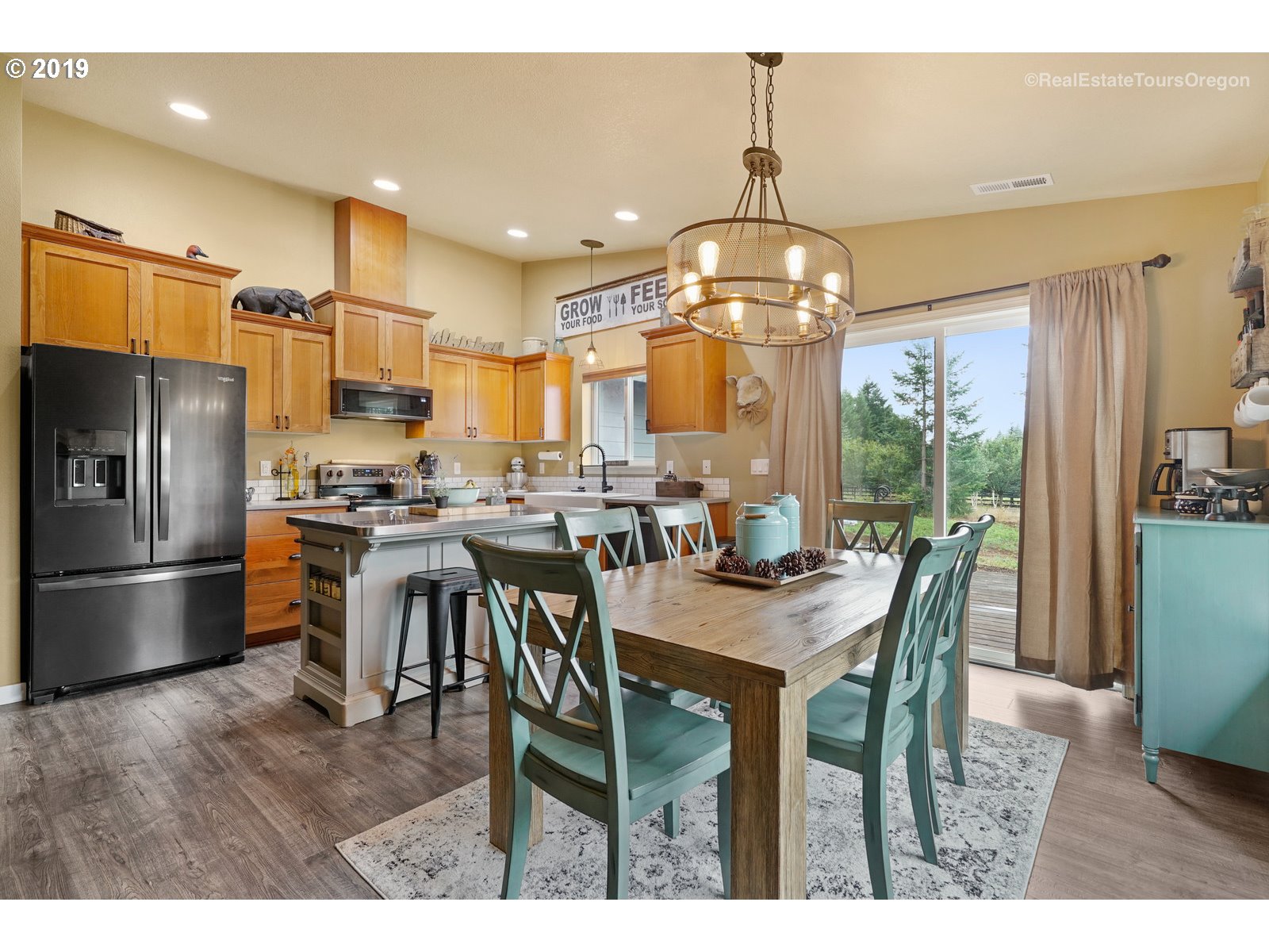 11909 Southeast Laughing Water Road Sandy, OR 97055 - Photo 6 of 22 a kitchen with stainless steel appliances kitchen island granite countertop a dining table chairs and refrigerator