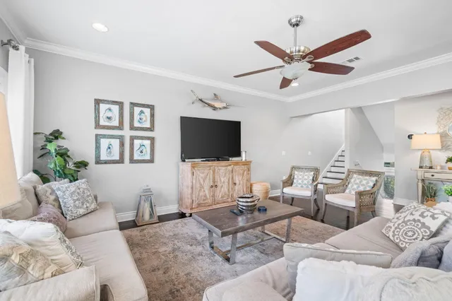a living room with furniture a flat screen tv and a window