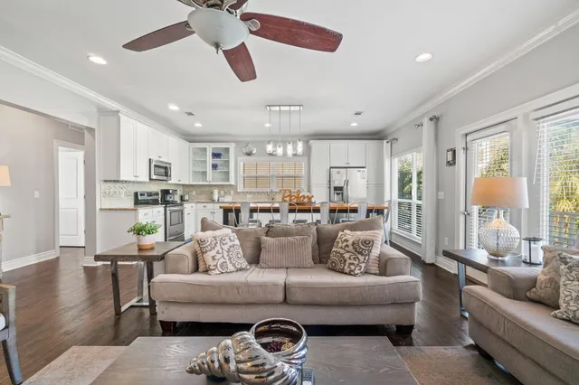 a living room with furniture and a large window with wooden floor