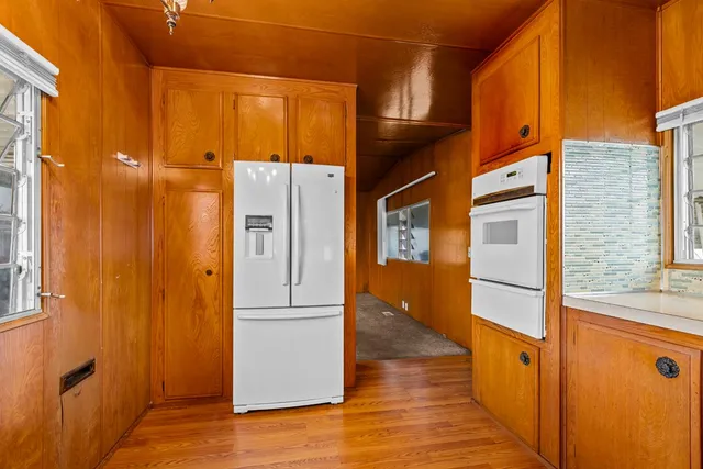 a view of a refrigerator a door and wooden floor