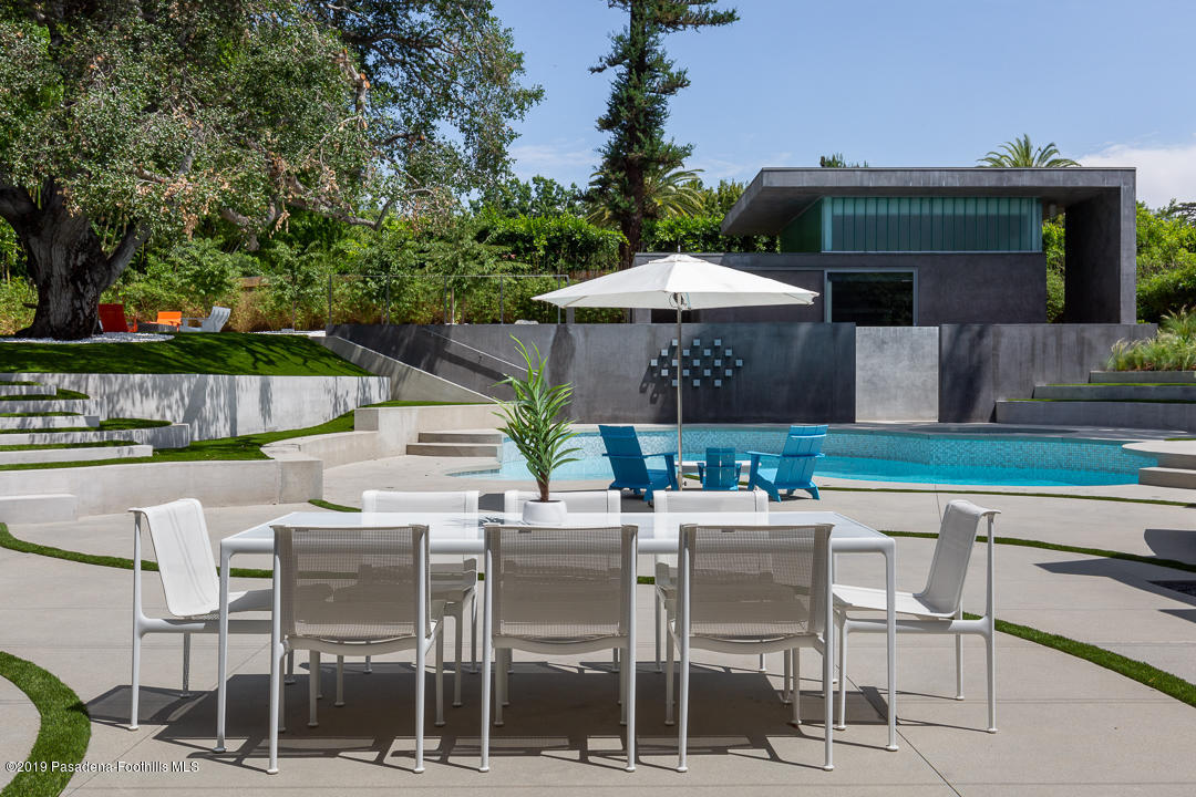 561 Woodland Road Pasadena, CA 91106 - Photo 30 of 41 a patio with a table and chairs under an umbrella