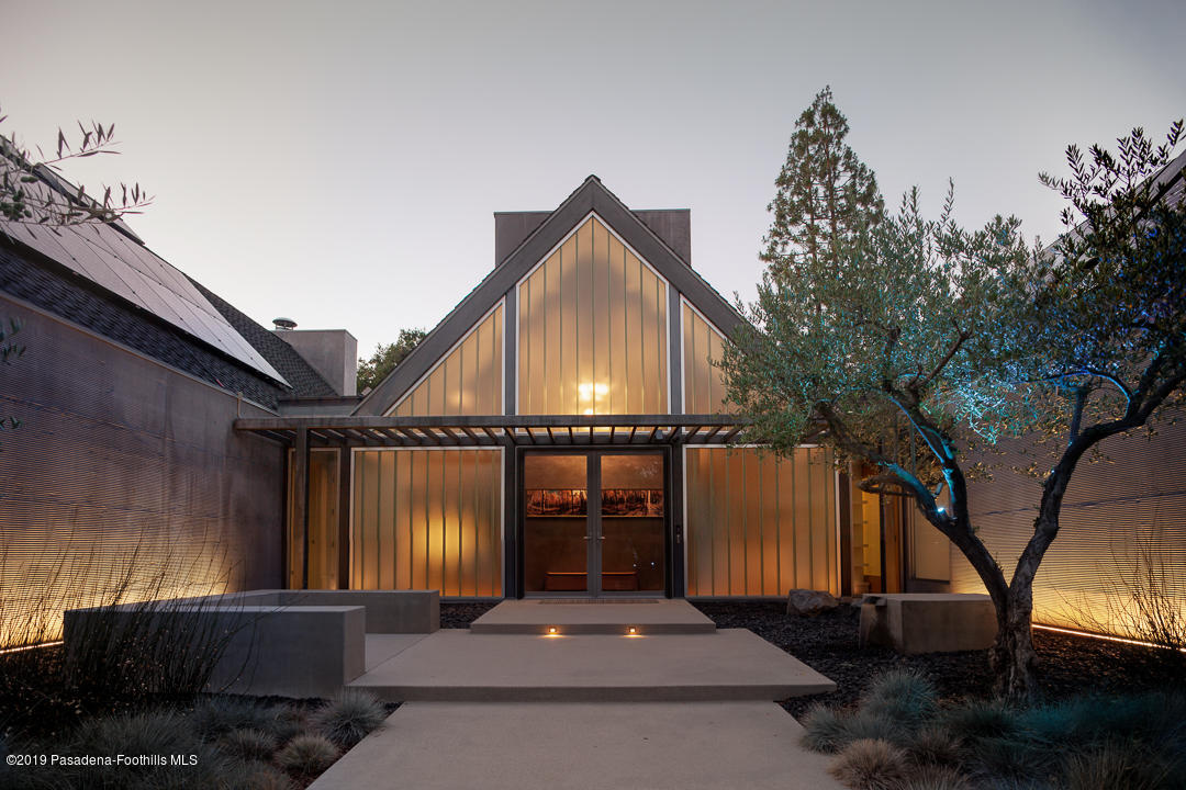 561 Woodland Road Pasadena, CA 91106 - Photo 6 of 41 a front view of a house with glass windows and a tree