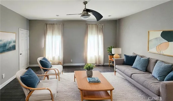 a living room with furniture ceiling fan and a window
