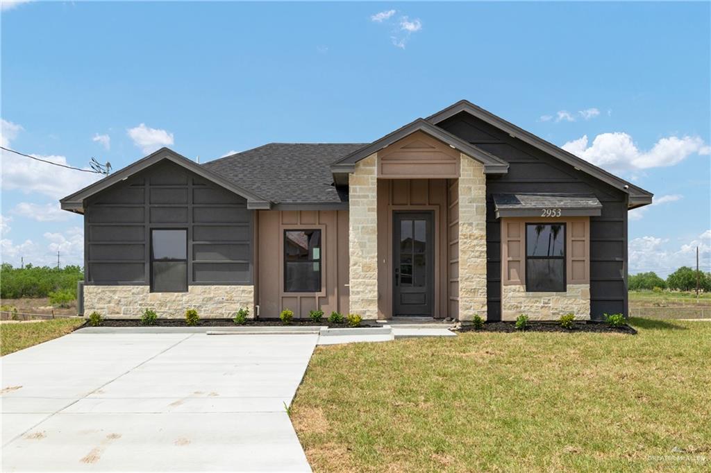 2953 Rio Red Circle Edinburg, TX 78541 - Photo 1 of 1 View of front facade featuring stone siding, a front lawn, board and batten siding, and a shingled roof