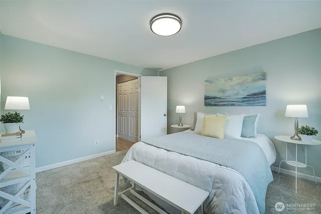 a bedroom with a bed and a lamp on dresser