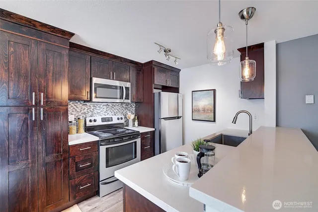 a kitchen with granite countertop a sink stainless steel appliances and cabinets