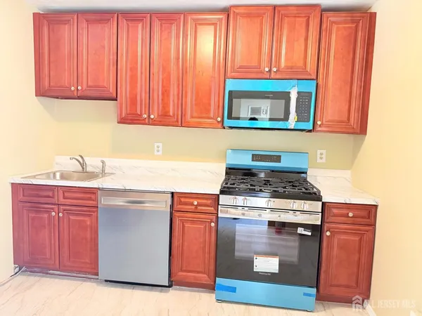 a kitchen with stainless steel appliances granite countertop a stove a microwave and a sink