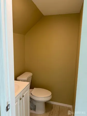 a white toilet sitting next to a white wall