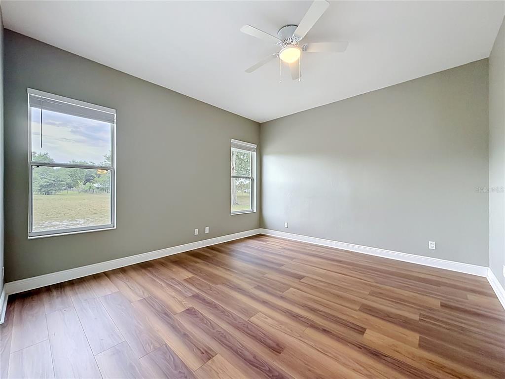 28549 Shirley Shores Road Tavares, FL 32778 - Photo 42 of 65 an empty room with wooden floor and windows