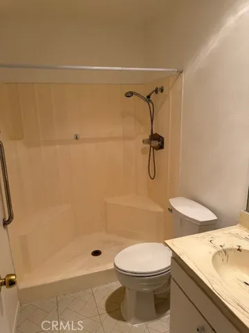 a bathroom with a shower a toilet and a sink