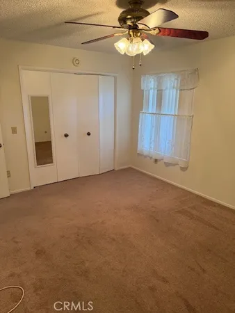 en empty room with windows and ceiling fan