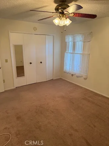 en empty room with windows and ceiling fan