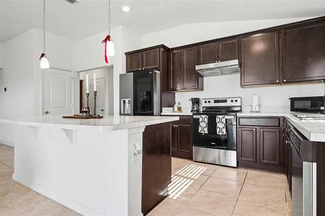 a kitchen with stainless steel appliances granite countertop a stove a sink and a refrigerator