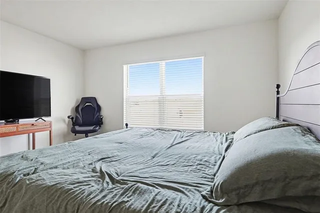 a bedroom with a bed and a flat screen tv