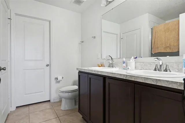 a bathroom with a granite countertop sink a toilet and a mirror