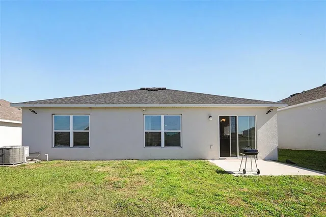 a backyard of a house with table and chairs