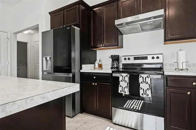 a kitchen with a refrigerator and a stove top oven
