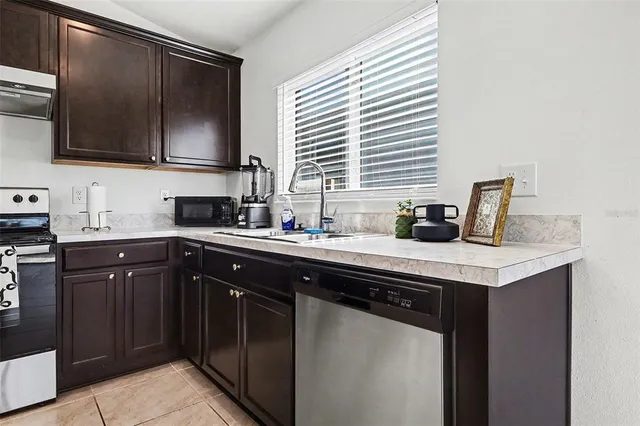 a kitchen with stainless steel appliances granite countertop a sink and a microwave