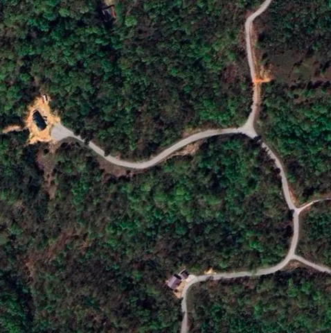 an aerial view of a house with a yard and outdoor seating