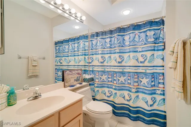 a bathroom with a sink a toilet and a shower curtain
