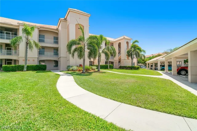 a view of a white house with a big yard and potted plants