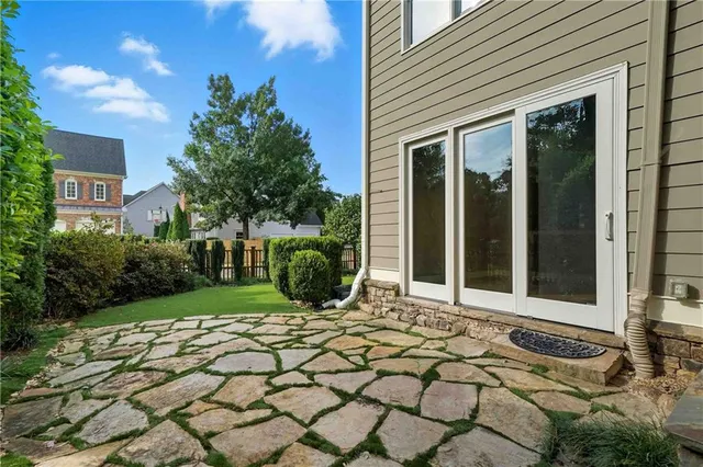 a view of a backyard with plants and large trees