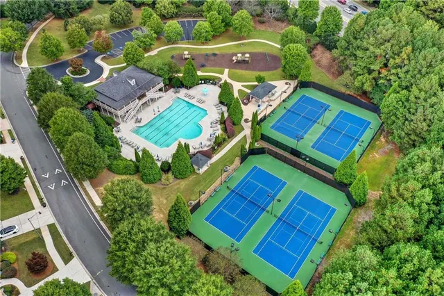 an aerial view of residential houses with outdoor space and trees