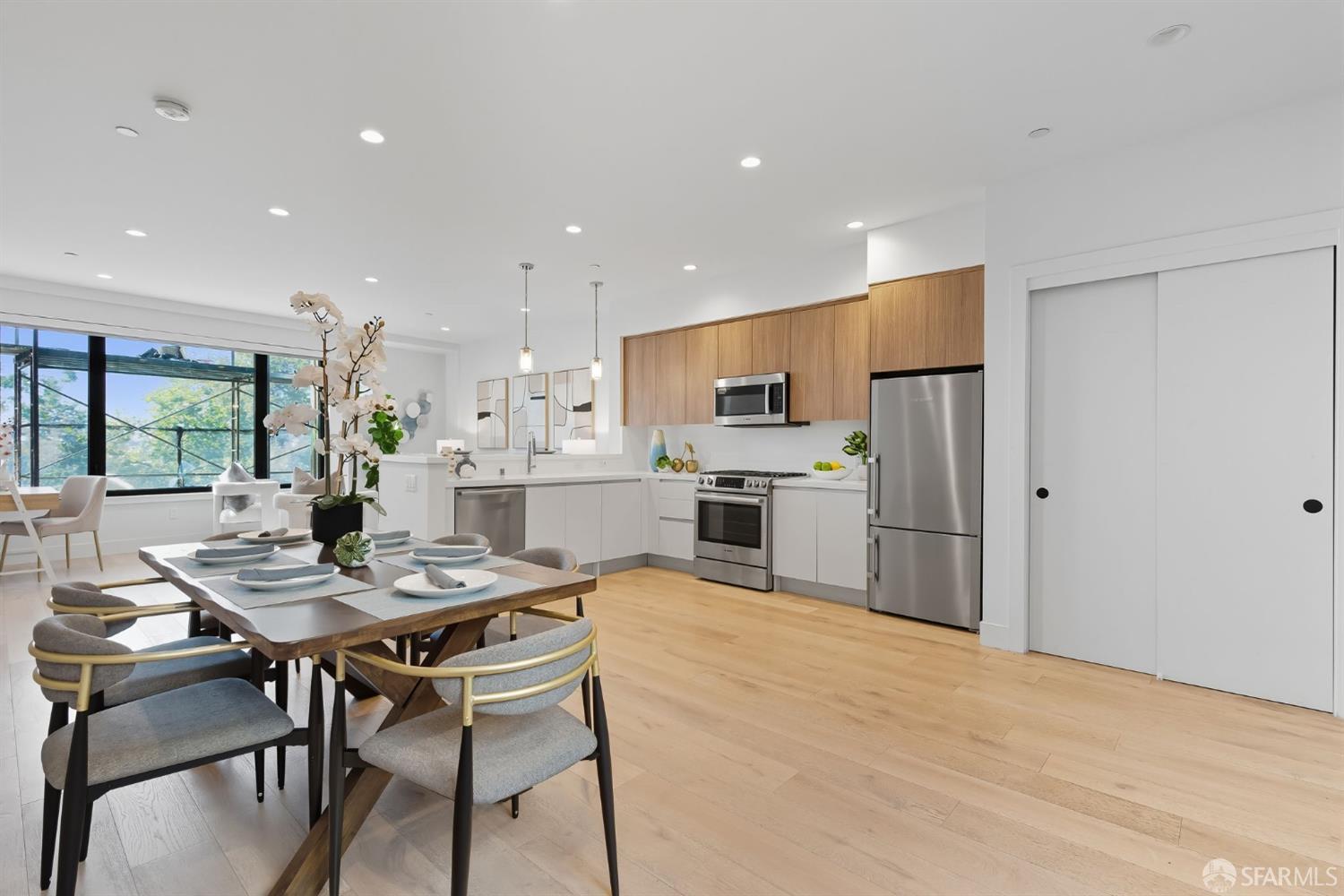 2747 San Pablo Avenue, Unit 406 Berkeley, CA 94702 - Photo 2 of 34 a kitchen with stainless steel appliances kitchen island granite countertop a dining table chairs refrigerator and cabinets