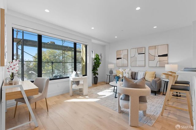 a living room with furniture a large window and a table