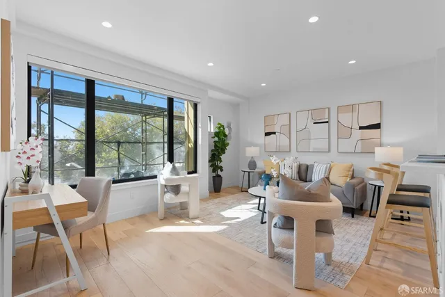 a living room with furniture a large window and a table