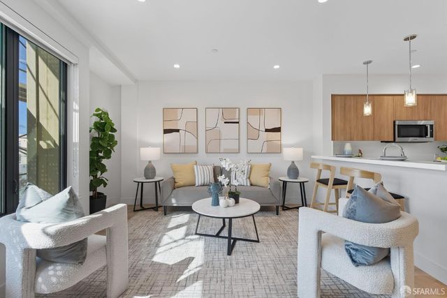 a living room with furniture and view of kitchen