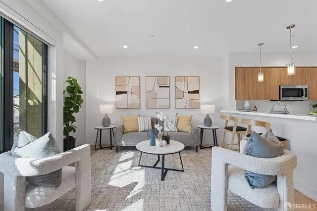 a living room with furniture and view of kitchen