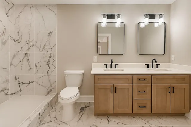 a bathroom with a bathtub shower sink vanity and toilet