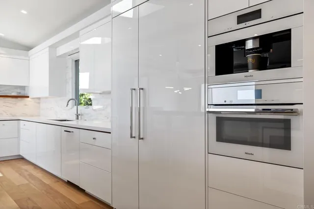 a kitchen with stainless steel appliances white cabinets and a sink