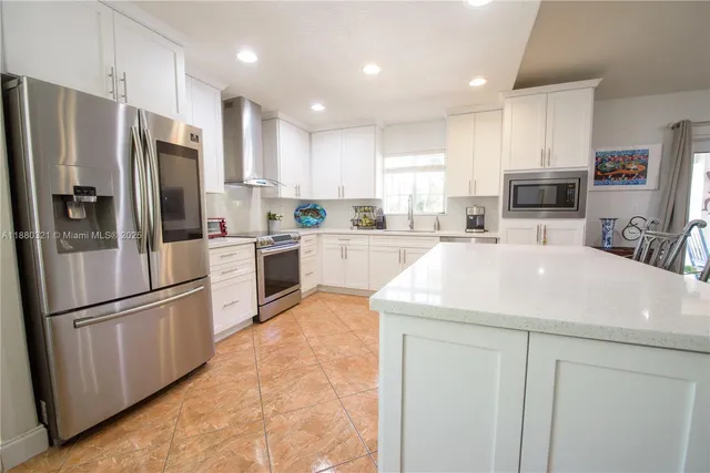 a kitchen with stainless steel appliances a refrigerator sink and microwave