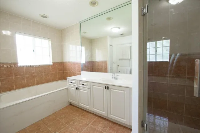 a spacious bathroom with a tub sink shower and mirror