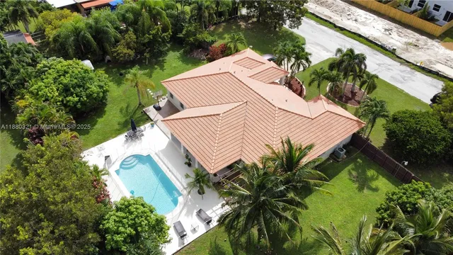 a view of a white house with a yard and potted plants