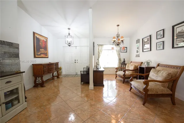 a kitchen with stainless steel appliances kitchen island granite countertop a table chairs and a refrigerator