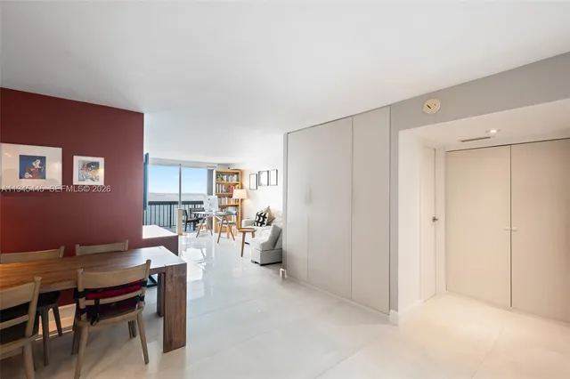 a living room with furniture a dining table and a refrigerator