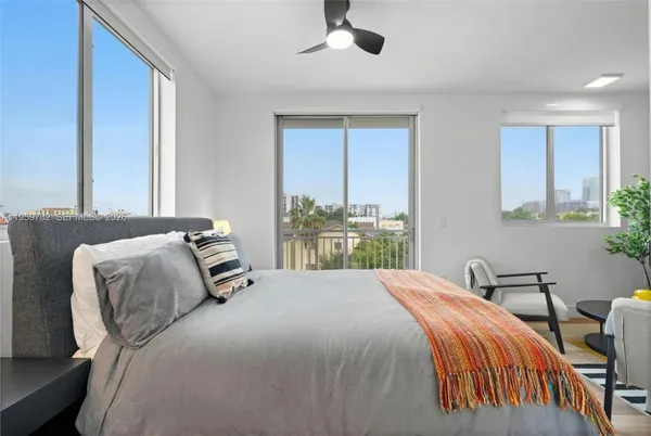 a bedroom with a bed and windows