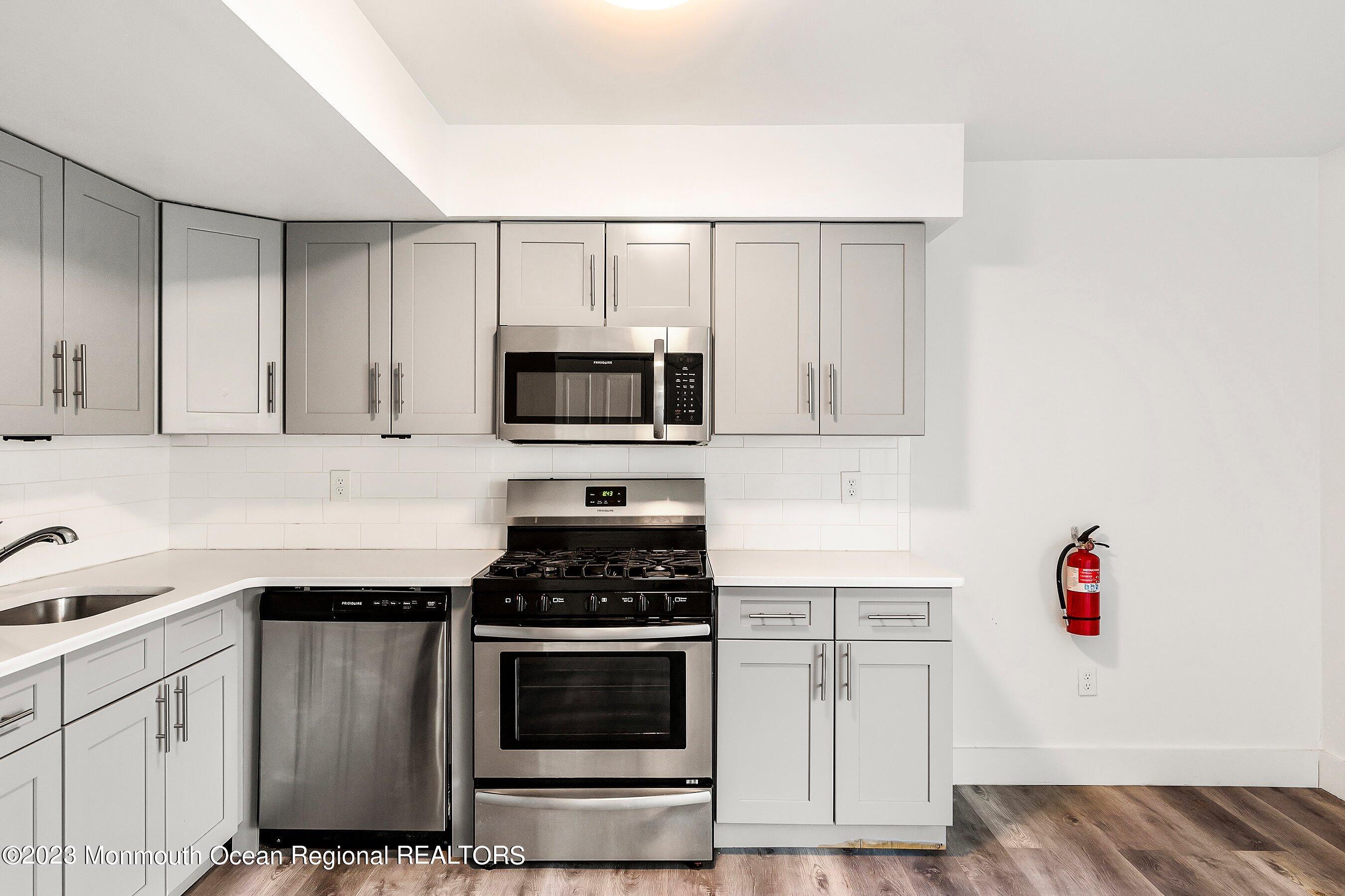 1012 Sawmill Road, Unit 6 Brick, NJ 08724 - Photo 14 of 24 a kitchen with granite countertop white cabinets and stainless steel appliances